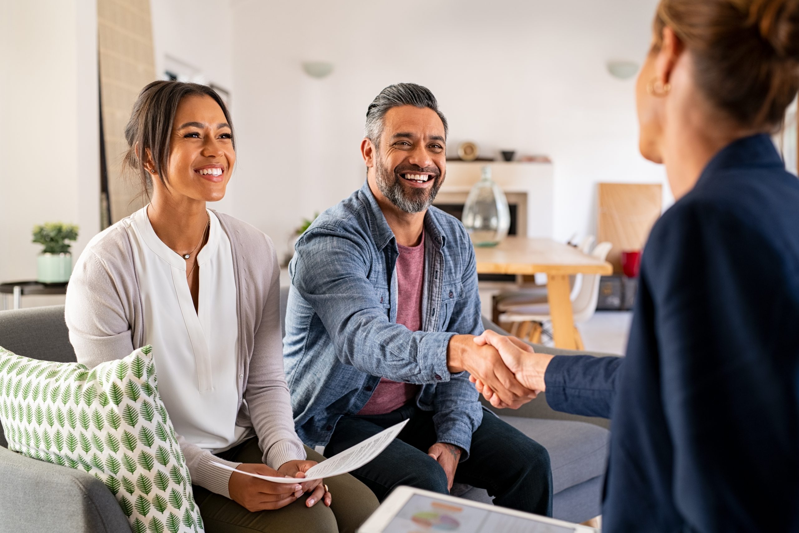 Couple shaking real estate specialist's hand