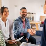 Couple shaking real estate specialist's hand